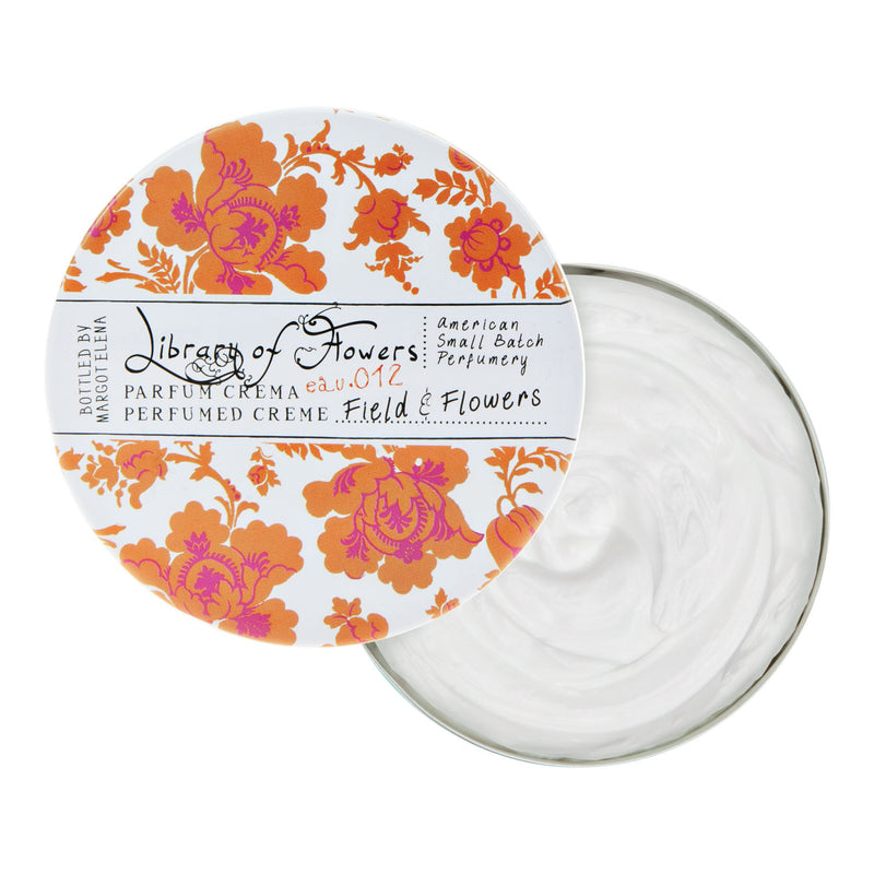 Open jar of Margot Elena Field & Flowers Parfum Crema with a floral orange and white design on the lid, labeled "Library of Flowers Parfum Crema - Field & Flowers.