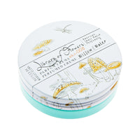 A round, decorative tin of moisturizing Willow & Water Parfum Crema labeled "Margot Elena" with sketches of mushrooms, a butterfly, and plants on a white background.