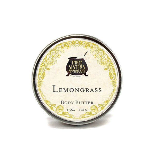 A 4 oz tin of Three Sisters Apothecary Lemongrass Body Butter features a vintage-style label and ornate yellow border, offering all-natural, artisanal skincare from Three Sisters Apothecary.