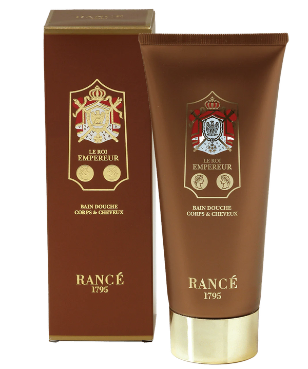 A brown and gold tube of Rancé Le Roi Empereur Body & Hair Shower Gel (200ml) stands beside its matching box, both featuring ornate gold crests—ideal for use with spicy oriental or Turkish Rose scents.