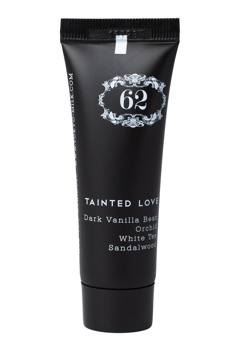 A black tube of Margot Elena's TokyoMilk Tainted Love Travel Size Hand Creme with white text describing its scents as dark vanilla bean, orchid, white tea, and sandalwood.