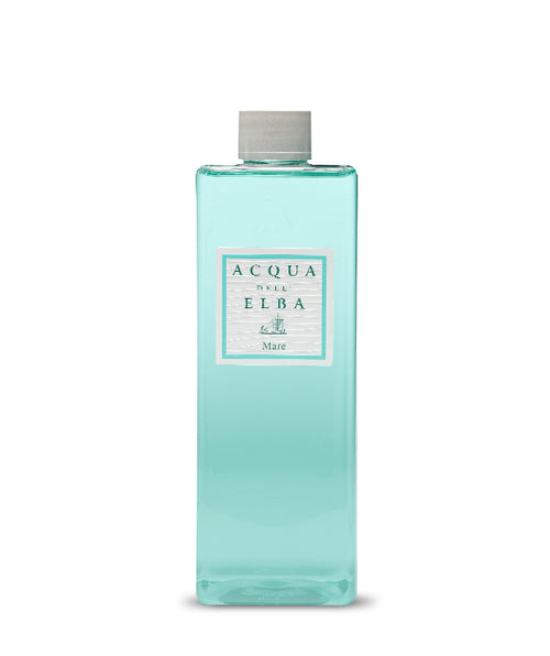 A rectangular clear bottle with light blue liquid and a gray cap, labeled "Acqua dell'Elba Mare Reed Diffuser Refill - 500ml" by Acqua dell'Elba, evokes an aquatic Mediterranean fragrance with a sailboat illustration.