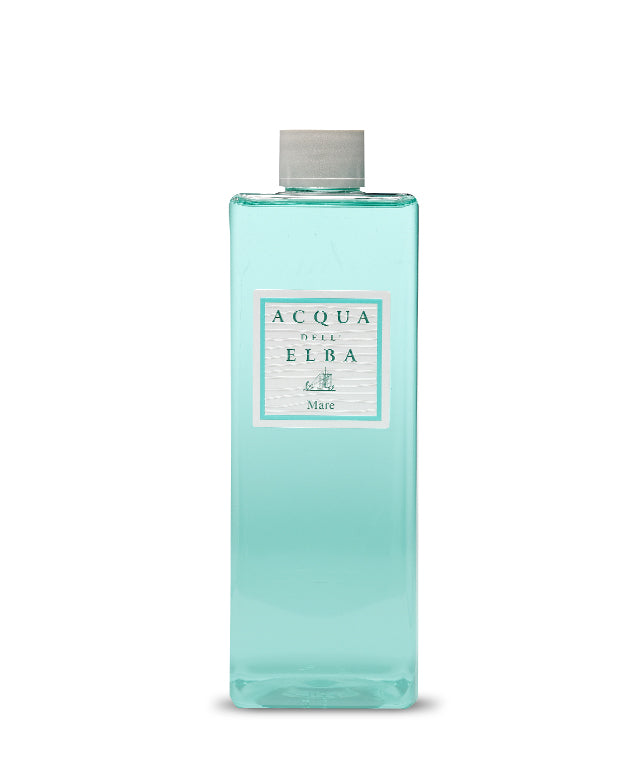 A rectangular clear bottle with light blue liquid and a gray cap, labeled "Acqua dell'Elba Mare Reed Diffuser Refill - 500ml" by Acqua dell'Elba, evokes an aquatic Mediterranean fragrance with a sailboat illustration.