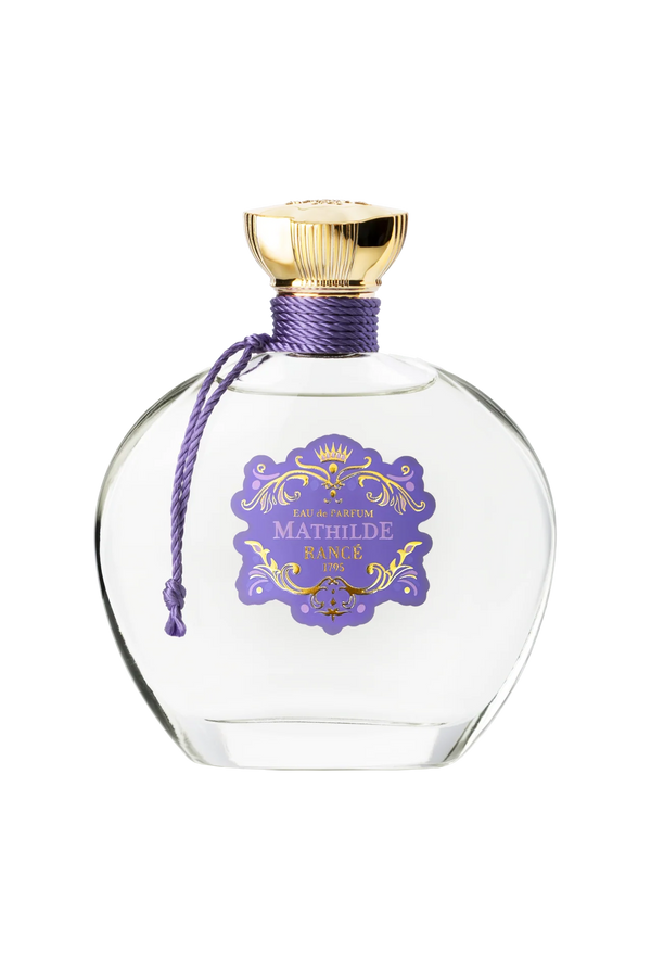 Rancé Mathilde Eau de Parfum - 100ml by Rancé comes in a clear glass bottle with a gold cap, purple cord, and ornate label, offering a refined floral woody fragrance that captures timeless elegance.