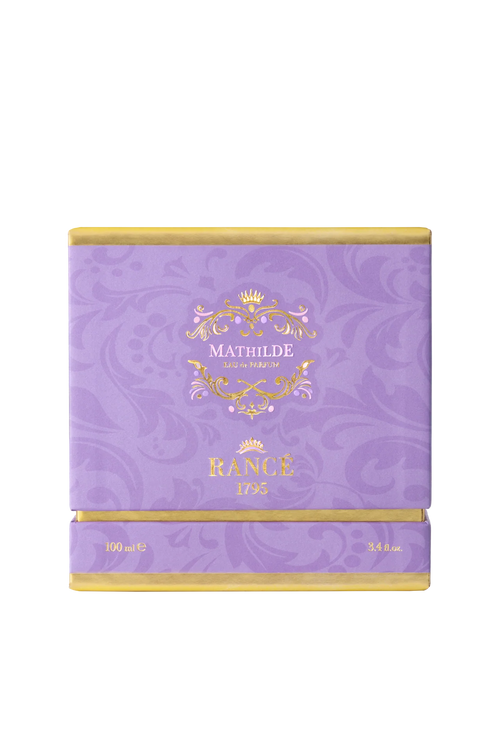 A square, purple luxury box with gold accents displays "Rancé Mathilde Eau de Parfum - 100ml" on the front. The subtle floral pattern hints at its floral woody scent, reflecting the elegance of the Rancé brand.