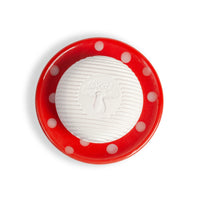 A round white soap with a mushroom design rests on the Kala Swedish Dream Red Mushroom Ceramic Soap Dish, featuring a red base with white polka dots, viewed from above on a white background.