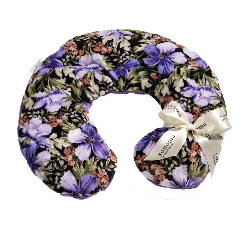 Introducing the Sonoma Lavender Midnight Garden Neck Pillow by Sonoma Lavender: a U-shaped neck pillow adorned with a beautiful floral fabric design in varying shades of purple, pink, and green. It features a white ribbon tied into a charming bow on the right side, with "Sonoma" elegantly printed on it. This lavender-infused neck pillow is perfect for adding soothing warmth to your self-care routine.