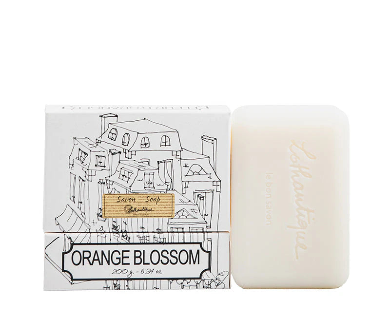 A white Lothantique Orange Blossom Soap 200gm bar sits by its box, which features sketch-style buildings and the label "Savon, Soap, 200g – 6.34 oz.