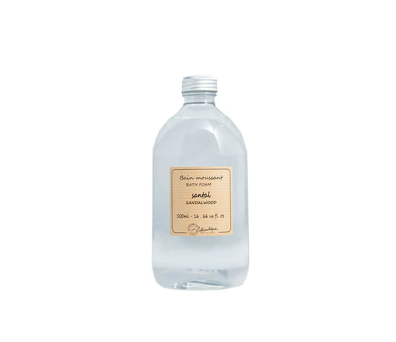 A transparent bottle of Lothantique Sandalwood Foam Bath (500ml) with a beige label is shown against a white background, offering a luxurious bathing experience.