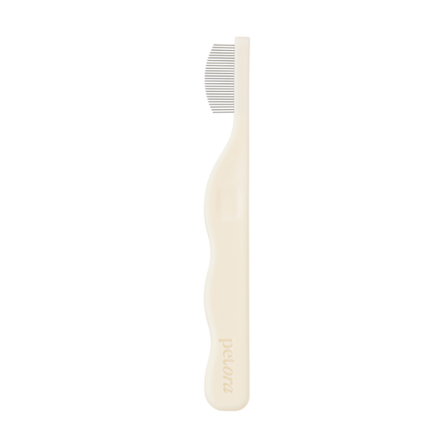 The Petora BRUSH ON ME Pet Facial & Eye Comb is a beige grooming tool with fine metal teeth and an ergonomic handle, embossed with "Petora," perfect for precise tear stain removal and facial grooming, shown in profile on a white background.
