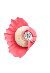 A bar of Roger & Gallet Red Ginger scented wellbeing soap in round packaging, featuring a prominent dark logo and text against a vibrant red and white striped background.
