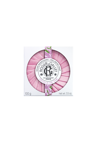 A pink, round Roger & Gallet Tea Leaf wellbeing soap labeled "roger & gallet - paris" in French, sealed with a black and white emblem, surrounded by a diagonal striped green and white border.