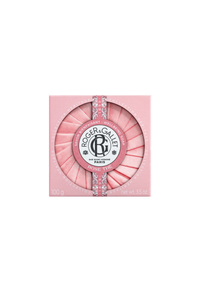 A round Roger & Gallet Tea Rose-scented soap, displayed in a pink case with a textured top resembling rose petals, decorated with a silver band and the company's logo.