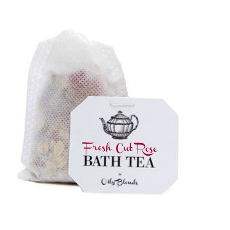 A Hampton Court "Bath Tea Single Bags - Rose Petal" in a white mesh bag filled with dried flowers is displayed against a pure white backdrop. The label, featuring a teapot illustration, emphasizes the calming properties of essential oils.