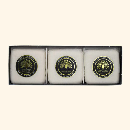 The English Soap Co. Winter Village Triple Soap Gift Box includes three scented soaps, each individually wrapped and labeled with a round emblem that reads "Merry Christmas Made in England." These charming Christmas gifts are beautifully arranged side by side in the box.