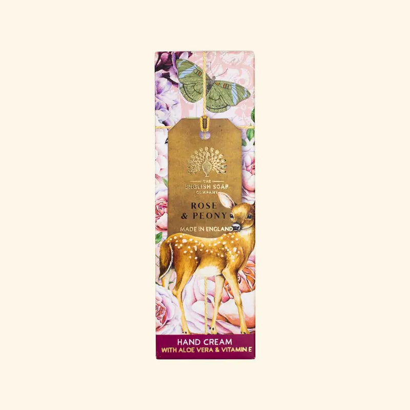 A rectangular box adorned with sophisticated floral patterns and a gold label at its center displaying "The English Soap Co. Anniversary Rose & Peony Hand Cream, Made in England." The box also features a deer illustration at the bottom and a banner at the base proclaiming "Hand Cream with moisturizing shea butter & Vitamin E.