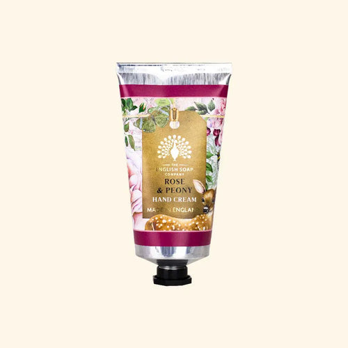 A tube of The English Soap Co. Anniversary Rose & Peony Hand Cream features packaging with a metallic finish and floral designs, including roses and peonies, along with small images of a deer. Enriched with hydrating aloe vera, the label reads "Rose & Peony Hand Cream Made in England.