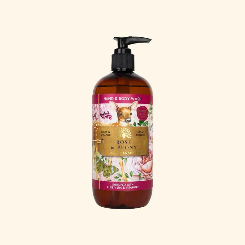 A brown pump bottle of The English Soap Co. Anniversary Rose & Peony Hand & Body Wash by The English Soap Co., labeled "Rose & Peony." The label displays images of flowers and reads "Hand & Body Wash," "VEGAN FRIENDLY," and "ENRICHED WITH ALOE VERA & VITAMIN E." The cap is black, and the bottle contains liquid soap.