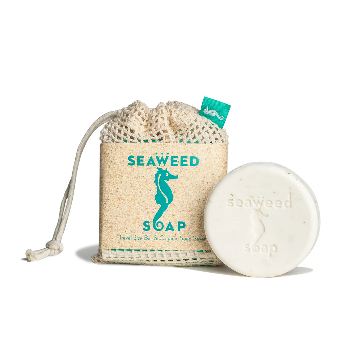 A round white Kala Swedish Dream Seaweed Travel Size Soap, embossed with "seaweed soap," sits by an Organic Soap Saver pouch labeled "SEAWEED SOAP" with a teal seahorse and text.