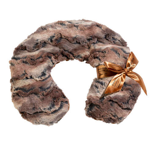 A plush, brown and grey faux fur Sonoma Timber Lake Warm Chestnut neck warmer with a golden bow on the side, featuring a text label on the ribbon. This heated Sonoma Lavender neck pillow is shaped in a circular form and isolated on a