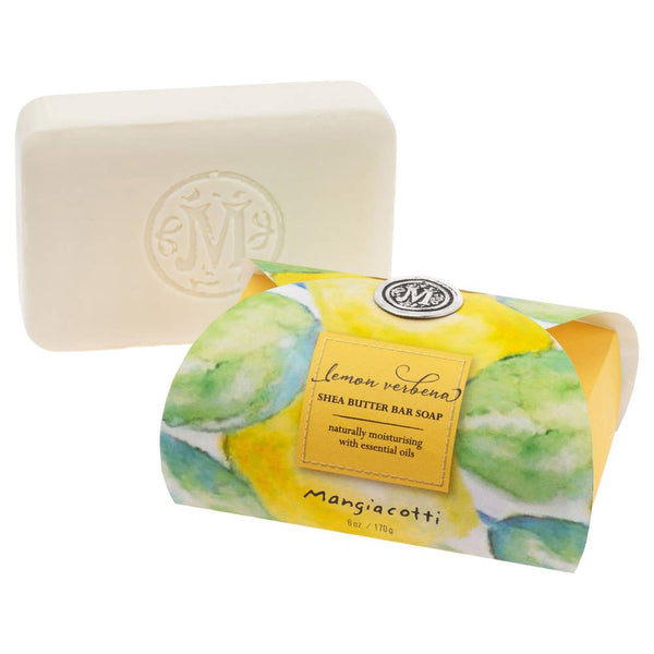 A rectangular white Mangiacotti Lemon Verbena Shea Butter Bar Soap 6 oz. with an embossed “M” is shown beside its box, featuring watercolor lemons and branding, made with natural ingredients.
