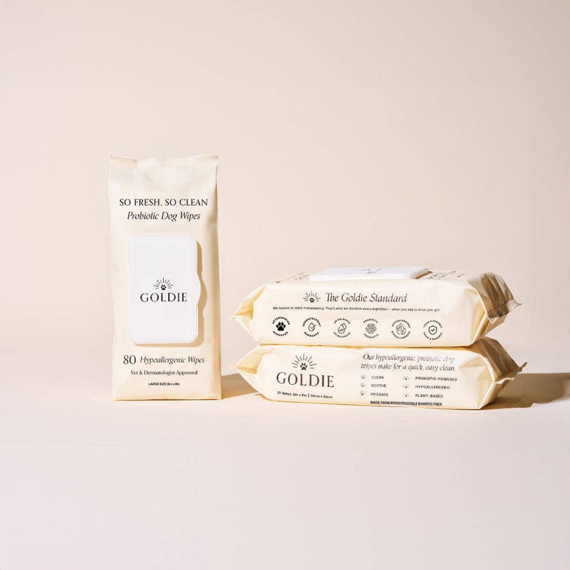 Three beige packs of Goldie - So Fresh, So Clean Probiotic Wipes are displayed on a light beige background, showcasing these gentle, hypoallergenic wipes—ideal for incorporating into your dog's daily grooming routine.
