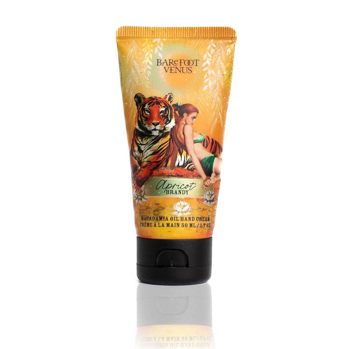 A tube of Barefoot Venus Apricot Brandy Hand Cream, decorated with a woman and tiger amid leafy patterns, displays product details on the front—infused with macadamia nut oil for nourishing botanical skin care.