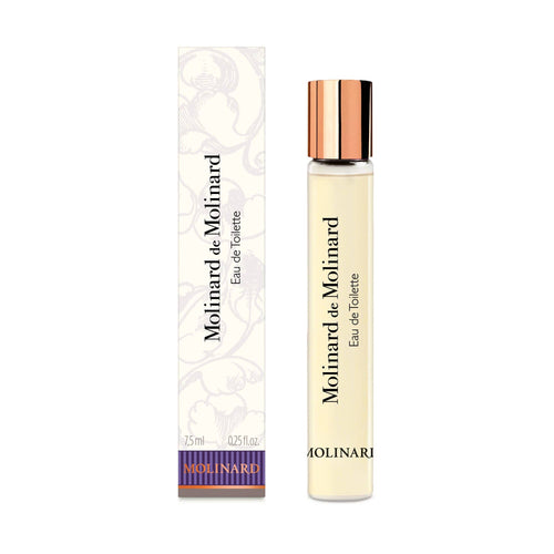 A Molinard - Molinard de Molinard Eau de Toilette Roll-On by Molinard, featuring a slim glass tube with a gold cap and black lettering, presented in a white box decorated with floral motifs and coordinating product details.