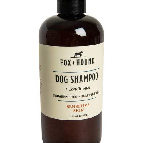 A brown bottle labeled "Fox + Hound - Dog Shampoo + Conditioner for Sensitive Skin" by Fox + Hound, paraben and sulfate free, against a light grey background.