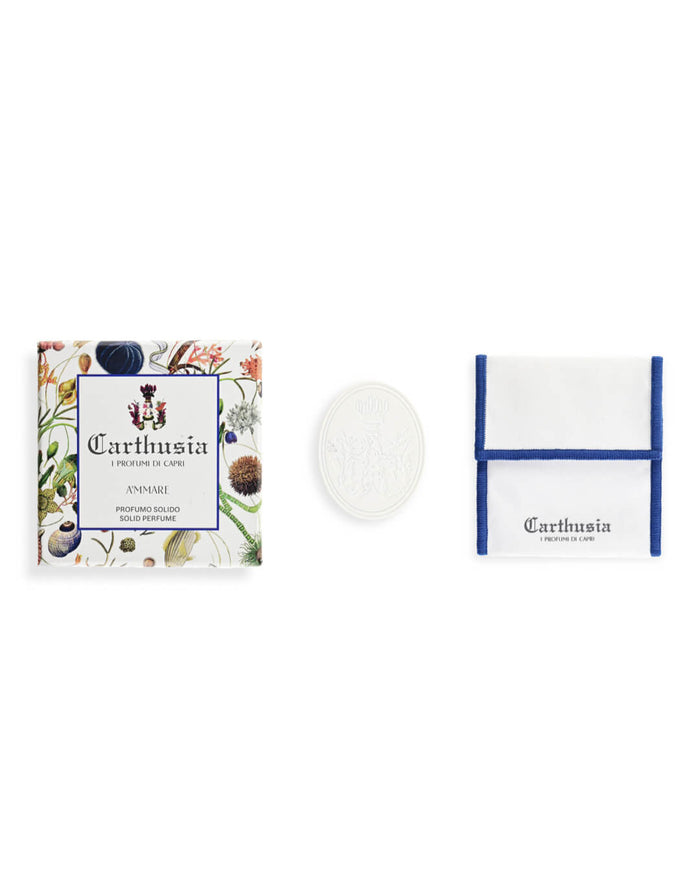 The Carthusia A'mmare Solid Perfume by Carthusia I Profumi di Capri includes a floral box, a round white perfume disc in a Zamak case, and a white pouch with blue trim and the Carthusia logo.