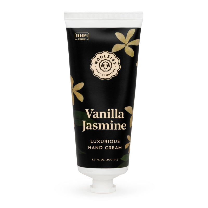 A tube of Woolzies Vanilla Jasmine luxurious hand cream with a black and gold design, featuring floral graphics and a logo of a smiling sun. It's labeled as containing natural ingredients and holds 3.5 fl