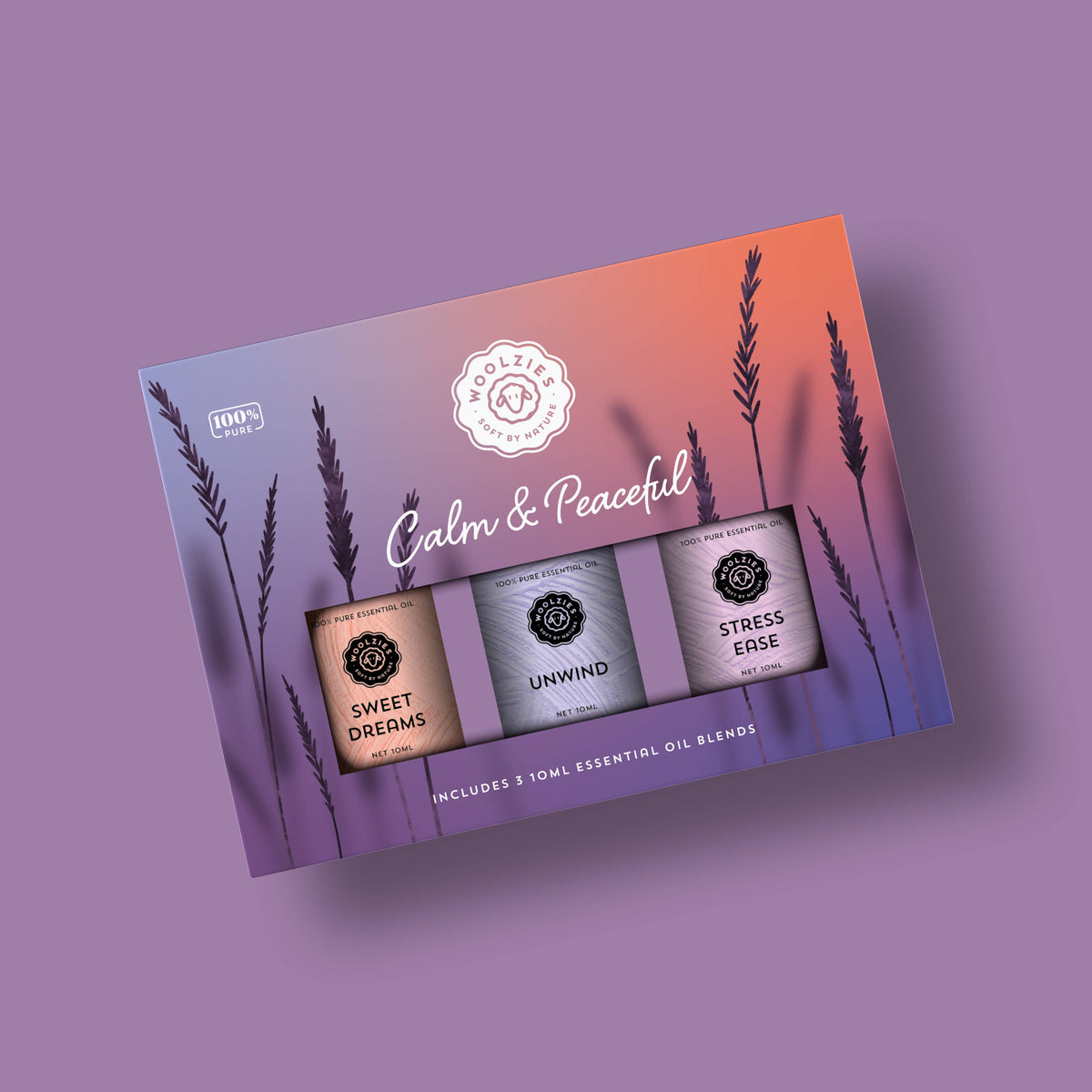 The Woolzies Calm & Peaceful Collection boxed set features three tranquil essential oils—Sweet Dreams, Unwind, and Stress Ease—set against a purple-orange gradient with lavender silhouettes. Brand: Woolzies.