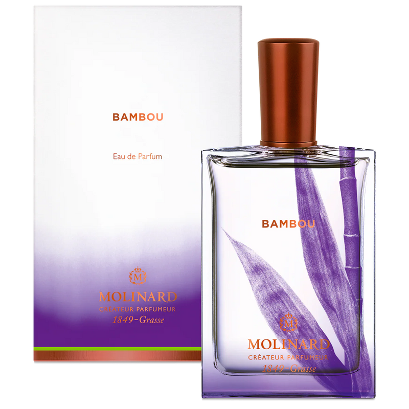 A Molinard Bambou Eau de Parfum bottle featuring a purple bamboo design and copper cap sits before its matching white and purple box, reflecting the Asian bamboo fragrance by Molinard.