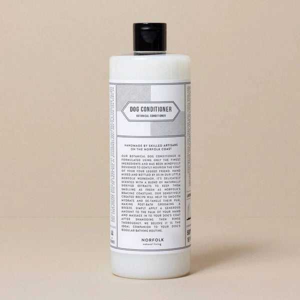 A white bottle of Norfolk Natural Living Coastal Walks Dog Conditioner with a black cap and detailed label, describing it as a vegan dog conditioner made with natural ingredients.