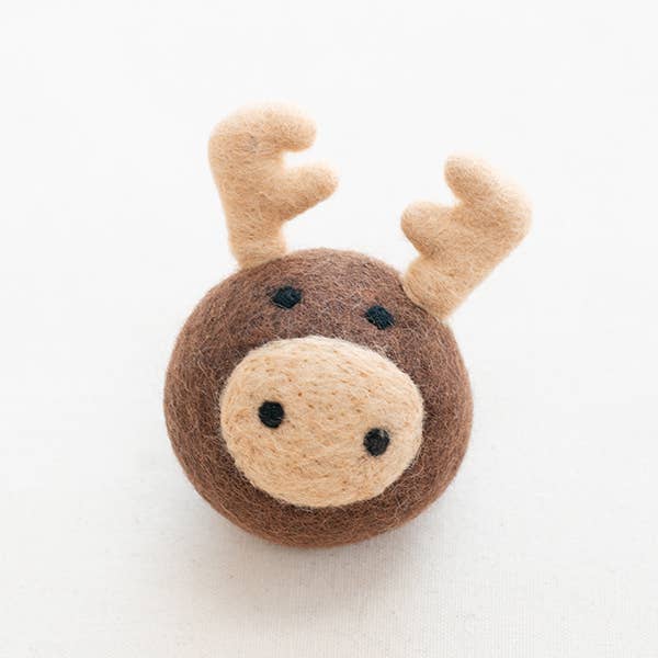 The MODERNBEAST Moose Beastball Wool Dog Toy is a round, handmade New Zealand wool ball resembling a moose with light brown antlers and snout, plus small black eyes and nostrils, shown on a plain white background.