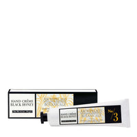 A white tube of Archipelago Botanicals’ Archipelago Black Honey Hand Crème is displayed with its black and gold box behind it. Both feature white labels with black and gold text and are infused with nourishing Amazonian Black Honey.