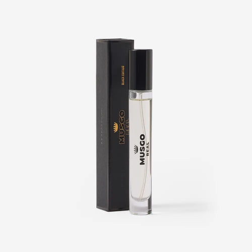 A clear glass travel-size bottle of Claus Porto Musgo Real Black Edition Eau de Toilette, labeled with the Claus Porto 1887 brand and black cap, stands beside its upright black box with gold text, set against a plain white background.