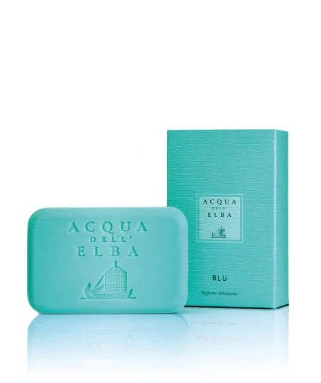 A bar of Acqua dell'Elba Blu Donna soap, infused with the essence of the ocean and adorned in turquoise, is beautifully presented alongside its coordinating box labeled "Blu.