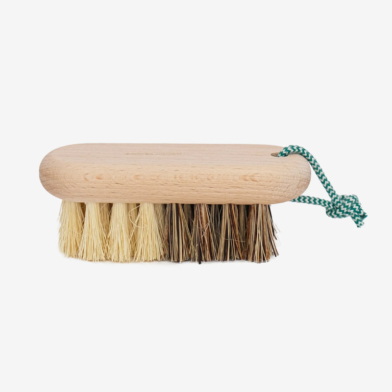 The Andrée Jardin Hard and Soft Fibres Vegetable Brush by Andrée Jardin features a mix of light and dark plant fiber bristles, complemented by a green and white checkered loop for easy hanging.