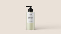 The image features a clear plastic bottle of L'floof STINKY Bergamot/Lavender Natural Dog Shampoo by L'floof, showcasing its cruelty-free formula. The 300ml bottle, fitted with a black pump dispenser, contains a light yellowish liquid and is set against a plain beige background.