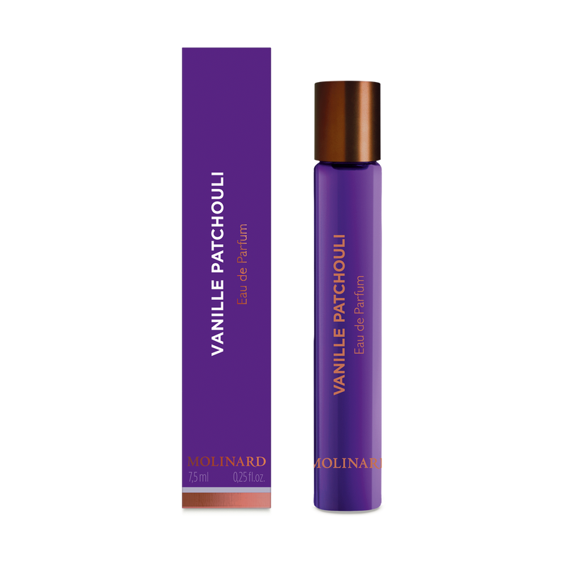A tall, slender purple Molinard Vanille Patchouli Eau de Parfum Roll-On stands by a matching box with copper accents and text. The bottle has a copper cap, holds 7.5 ml (0.25 fl oz), and exudes the brand’s signature oriental elegance.
