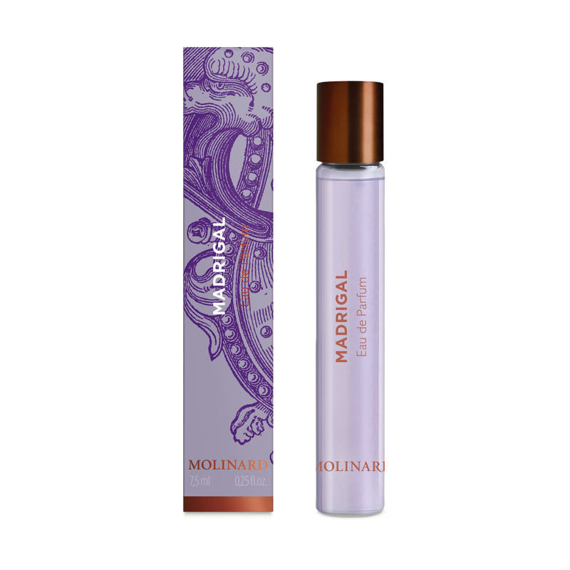 The Molinard Madrigal Roll-On by Molinard is a bold perfume for the modern gentleman, featuring a glass bottle with a copper cap beside its ornate purple box with copper accents.