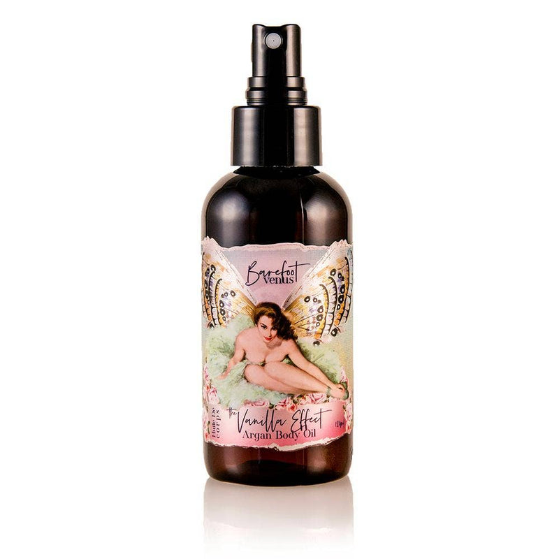 A bottle of Barefoot Venus The Vanilla Effect Argan Body Oil with a pump dispenser is featured against a plain white background. The label highlights an artistic illustration of a woman surrounded by decorative elements, suggesting a deeply hydrating experience.