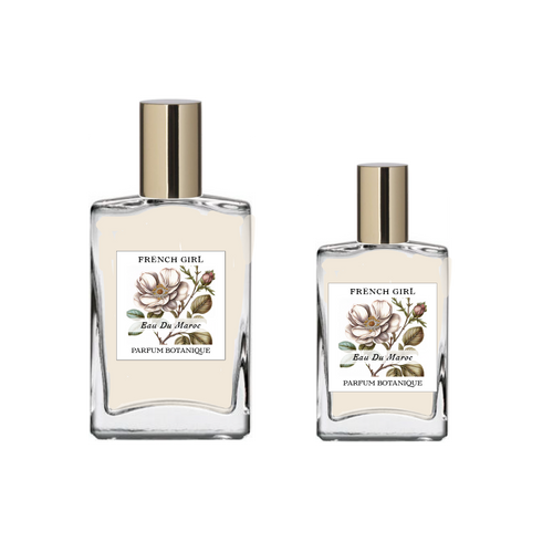 Two glass bottles labeled "FRENCH GIRL Eau Du Maroc Organic Vegan Natural Aromatherapy Perfume," featuring floral illustrations and gold caps, display this alcohol-free vegan scent made with essential oils, set against a plain white background.