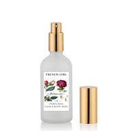 A frosted glass spray bottle with a gold nozzle, labeled "FRENCH GIRL Perfumed Hair & Body Mist." This alcohol-free, vegan mist comes in 3 scents and is part of the Mediterranean Perfume Collection.