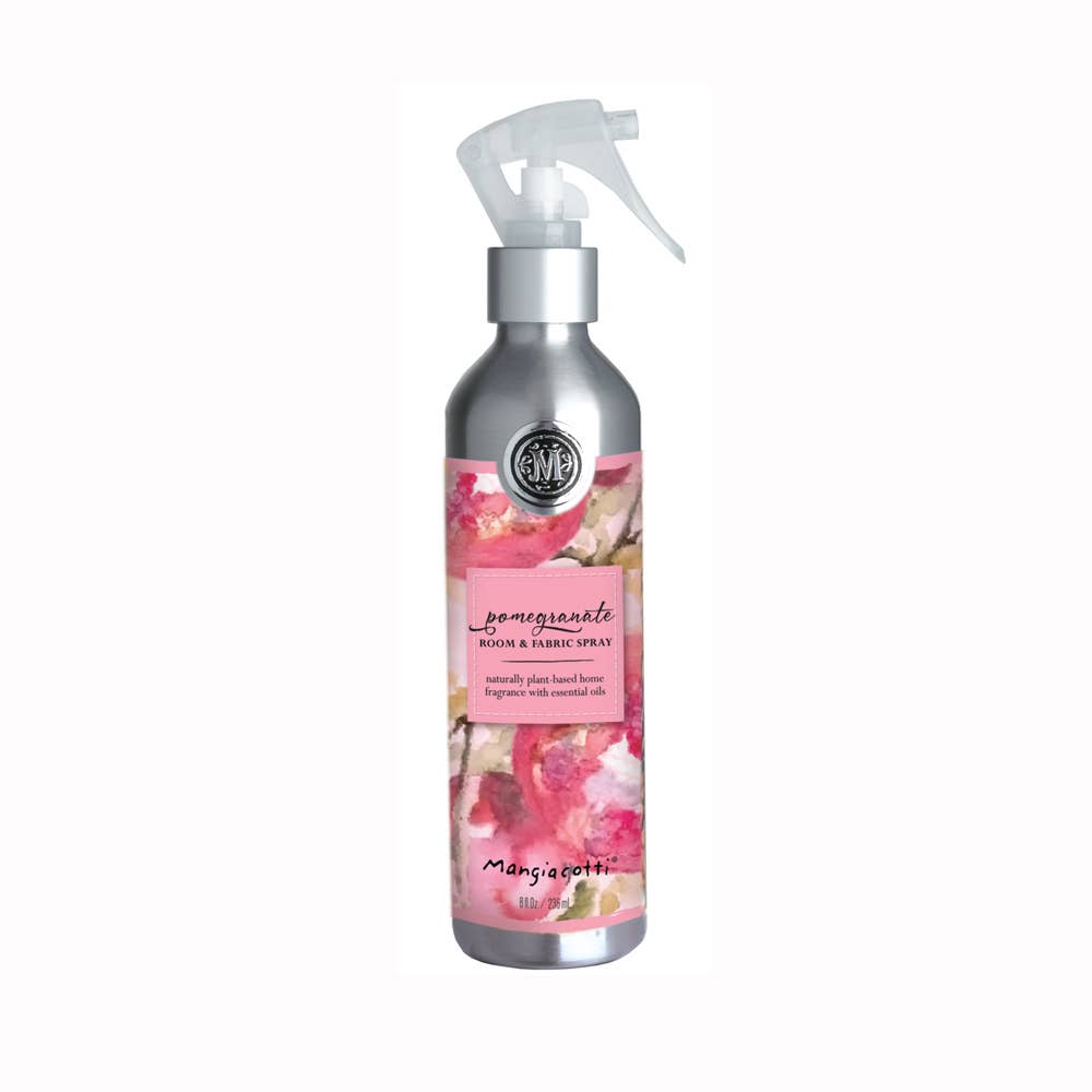 The Mangiacotti Pomegranate Room & Fabric Spray is a silver bottle with a spray nozzle, pink and red watercolor design, and essential oils. "Mangiacotti" is printed at the bottom.