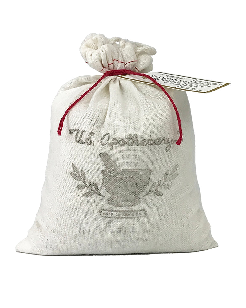 A U.S. Apothecary Chamomile & Honey Bath Soak Bag with the text "u.s. apothecary" and an image of a mortar and pestle. It features a red string closure and a letter-pressed hang tag.