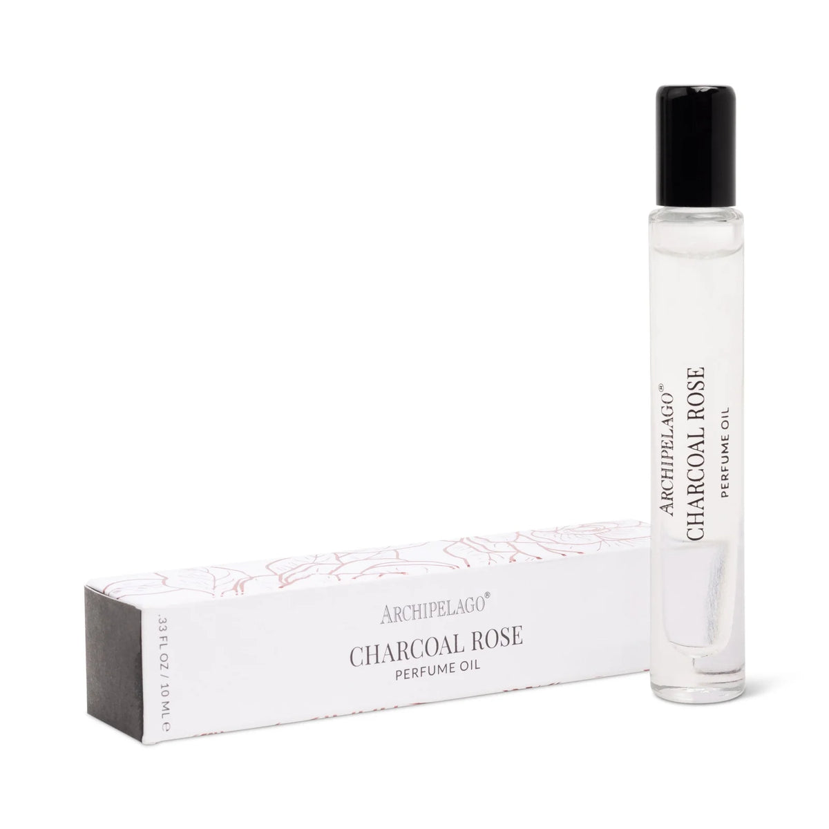 A clear glass rollerball bottle of Archipelago Botanicals Charcoal Rose Perfume Oil stands upright beside its white box with pink accents—a chic choice for fans of long-lasting fragrance.
