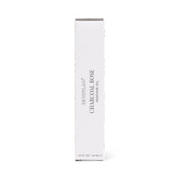A white rectangular box labeled "Archipelago Charcoal Rose Perfume Oil" by Archipelago Botanicals stands upright against a plain white background, highlighting this long-lasting, convenient rollerball fragrance.