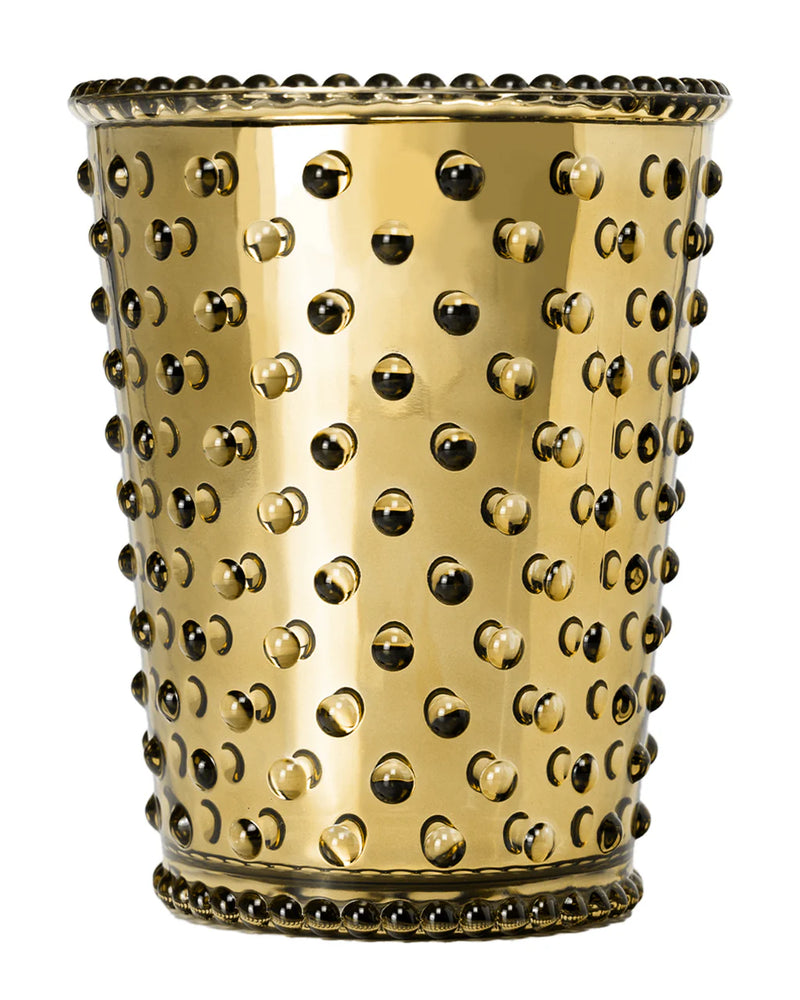 The Simpatico No. 621 Chrome Holiday Spice Hobnail Glass Candle features shiny gold-colored textured glass with raised bumps and beaded accents—an elegant vessel for natural soy wax from the Simpatico brand.